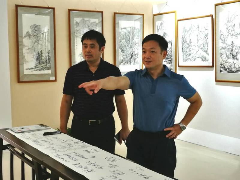 2018年9月11日学校党委陈湘如副书记（右）参观beat365中国在线体育第一届师生书画作品展。